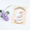 A congratulations card featuring a three-tiered wedding cake decorated with colorful flowers. The word 