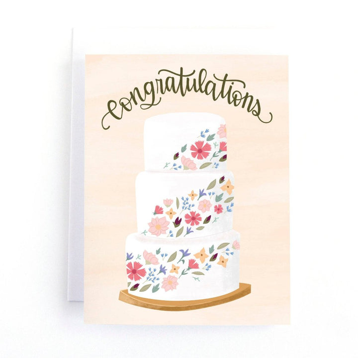 A congratulations card featuring a three-tiered wedding cake decorated with colorful flowers. The word 