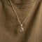 A copper oval locket necklace with an engraved evil eye design, featuring an eye with radiating lines and crescent moons, hanging from a gold chain. This is a protective and spiritual piece of jewelry, available in Ottawa, Ontario, Canada.