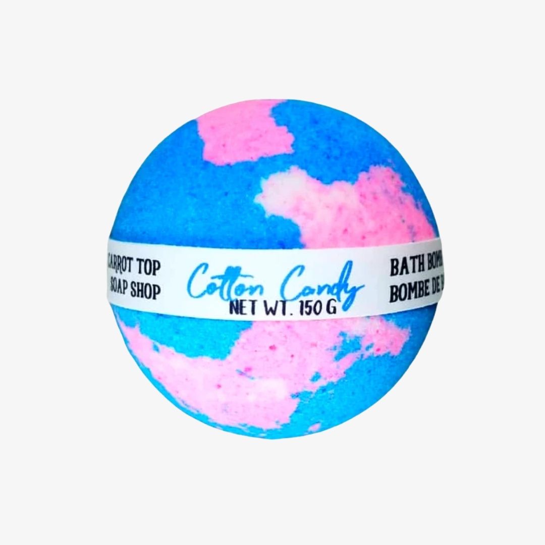 A spherical bath bomb with a blue and pink marbled pattern, wrapped in a white paper band that reads 'Cotton Candy' and 'BATH BOMB'.