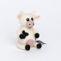 Stuffed cow toy with black spots on a white background