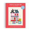 Punch needle kit packaging with a colorful house illustration on a red background