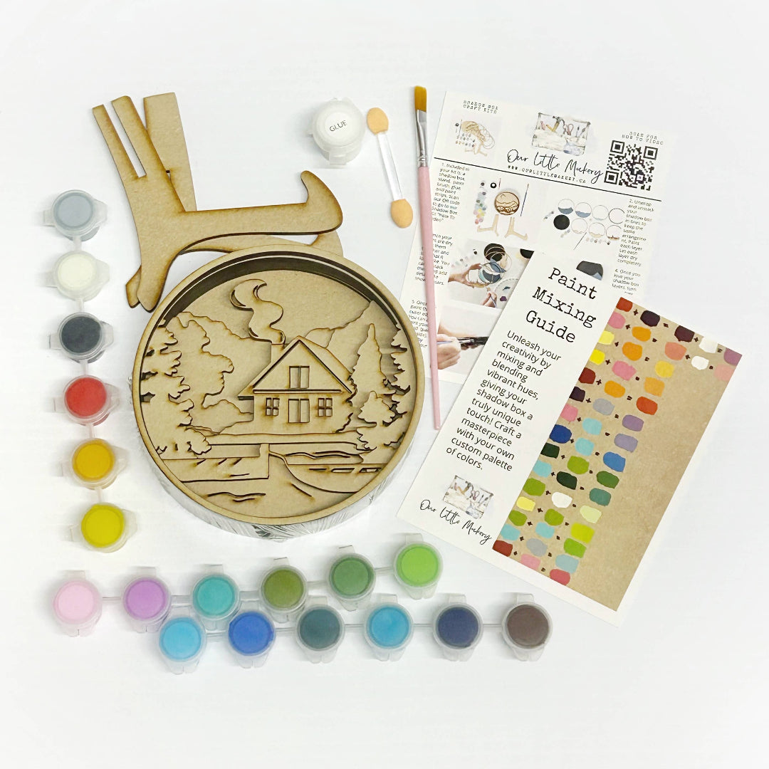 Wooden ornament with house design, paint cans, brushes, and a color mixing guide on a white background