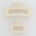 Two beige hair clips with rectangular designs on a white background