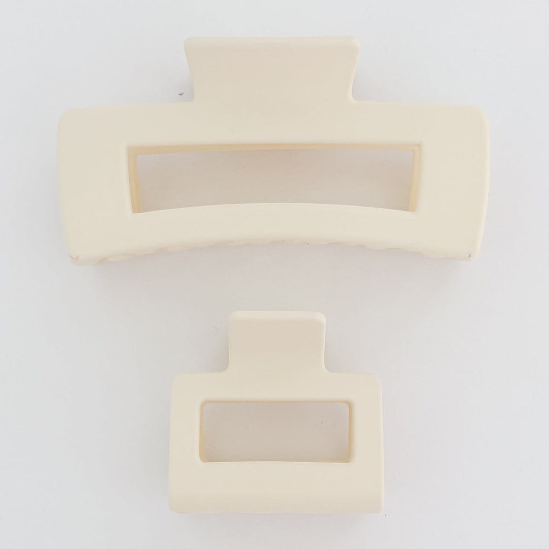 Two beige hair clips with rectangular designs on a white background