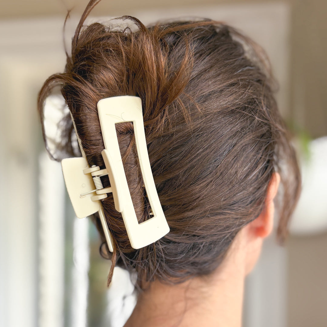 Close-up of a beige hair clip in a person's hair with a blurred background