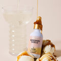 Shroom Soda bottle with caramel drizzle over ice cream on a beige background