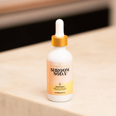 Bottle of 'Shroom Soda' on a beige surface