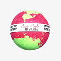 A spherical bath bomb with a pink and neon green marbled pattern, wrapped in a white paper band labeled 'Crisp Apple' and 'Carrot Top Soap Shop'.