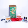 A cardboard box containing a Kiss Naturals Bath Bomb Kit. The box is green and white with the product name and a colorful illustration of bath bombs. It states that the kit is 100% natural, made in Canada, and suitable for ages 6 and up.