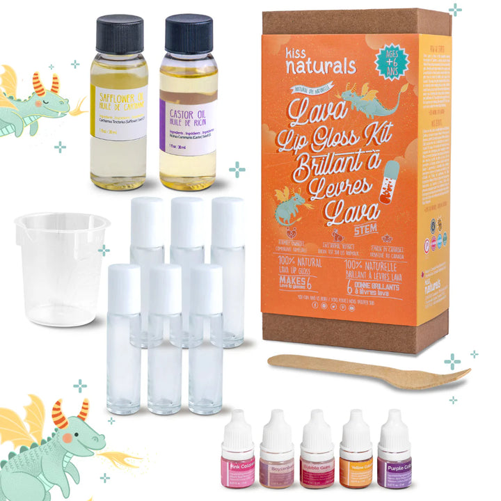 A cardboard box containing a Kiss Naturals Lava Lip Gloss Kit. The box is orange and white with the product name and a colorful illustration of a dragon. It states that the kit is 100% natural, made in Canada, and suitable for ages 6 and up.