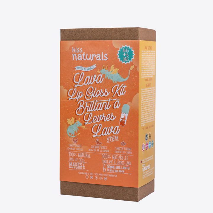 A cardboard box containing a Kiss Naturals Lava Lip Gloss Kit. The box is orange and white with the product name and a colorful illustration of a dragon. It states that the kit is 100% natural, made in Canada, and suitable for ages 6 and up.
