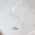 Silver necklace with a small pendant on a light background