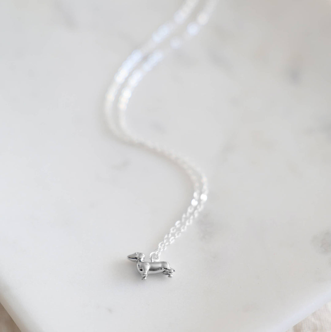 Silver necklace with a small pendant on a light background