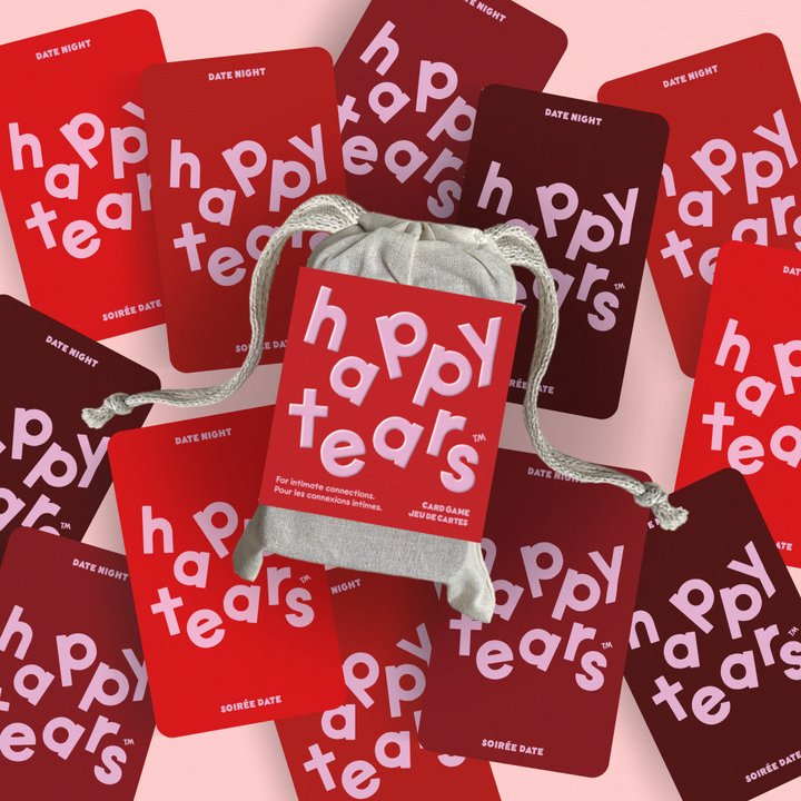 Happy Tears Intimate Connections card game, Ottawa. Red conversation cards in grey drawstring bag. 'Happy Tears' logo, bilingual text: 'For Intimate connections', 'Pour les connexions intimes'. Fun card game for couples.
