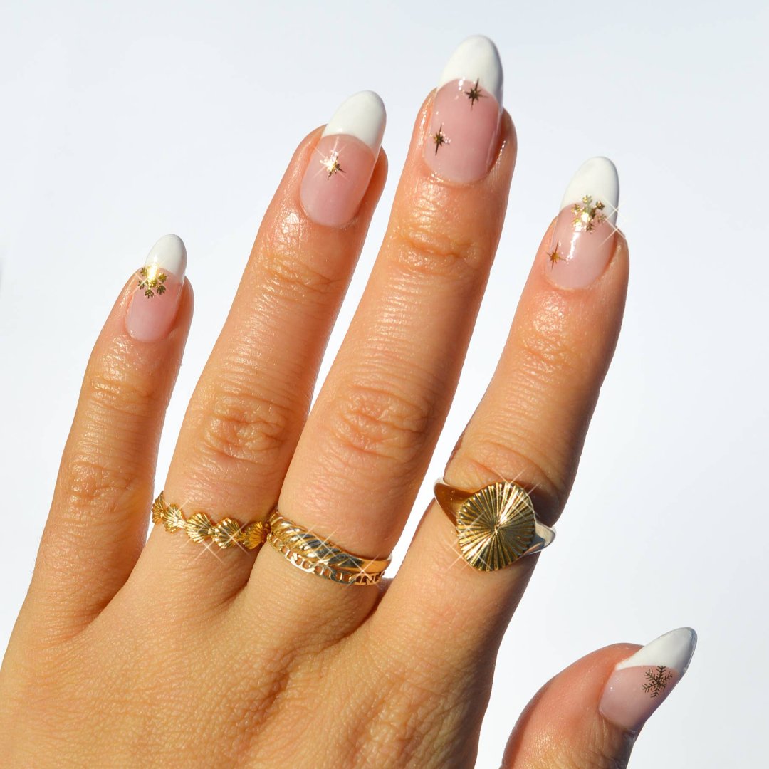 A sheet of Christmas-themed nail art stickers. The sheet is pink and has the brand name "Deco Beauty" printed on it. There's a section titled "Deco the Halls" and instructions on how to apply the stickers. The stickers include various Christmas-themed designs like snowflakes, bells, ornaments, and candy canes.