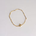 Gold chain bracelet on a light gray background
