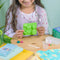 A cardboard box containing a Kiss Naturals Glycerin Soap Kit. The box is blue and white with the product name and a colorful illustration of penguins. It states that the kit is 100% natural, made in Canada, and suitable for ages 6 and up.