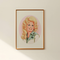 Framed portrait of a blonde woman with a pink background on a wall.