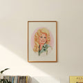Framed portrait of a blonde woman with a pink background on a wall.