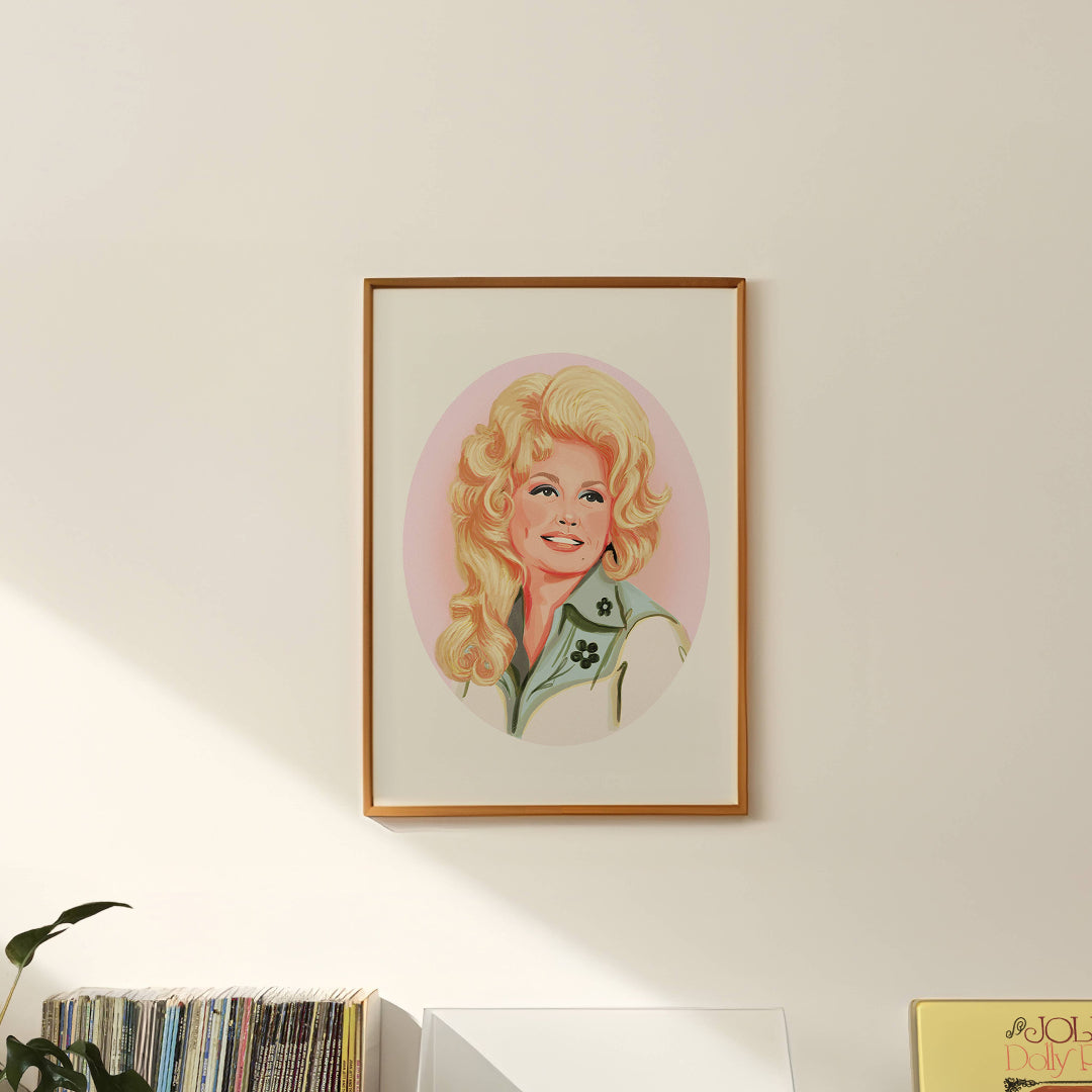 Framed portrait of a blonde woman with a pink background on a wall.