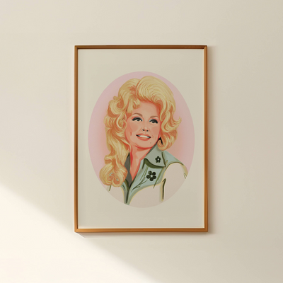 Framed portrait of a blonde woman with a pink background on a wall.