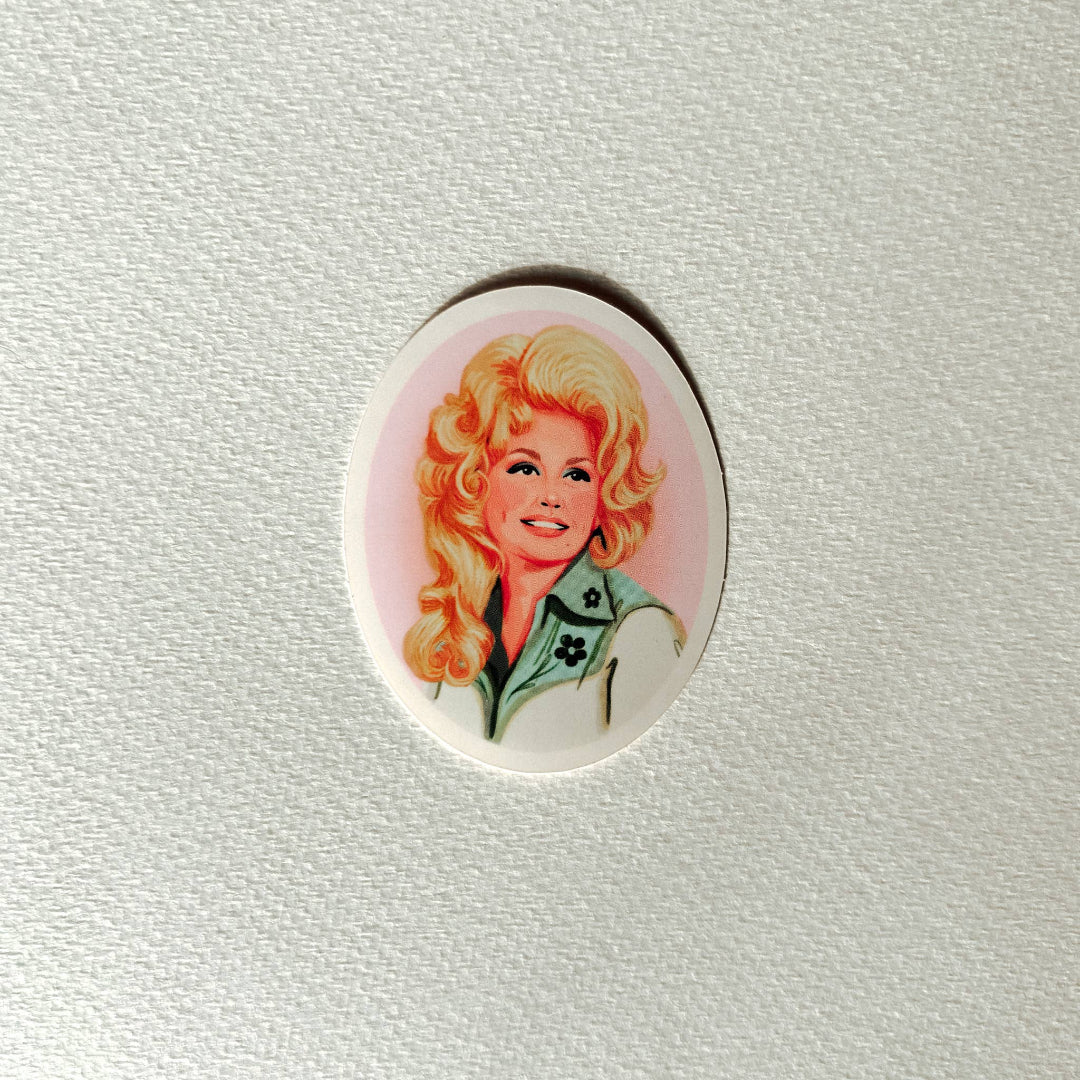 An oval-shaped pinback button featuring a vintage-style illustration of a smiling blonde woman with a green and white jacket, set against a textured off-white background.