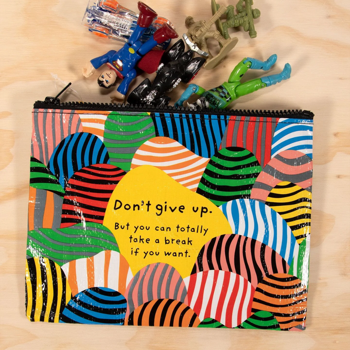 A zippered pouch with a playful design. The pouch has a bright yellow background with colorful, striped shapes resembling hills. The text 