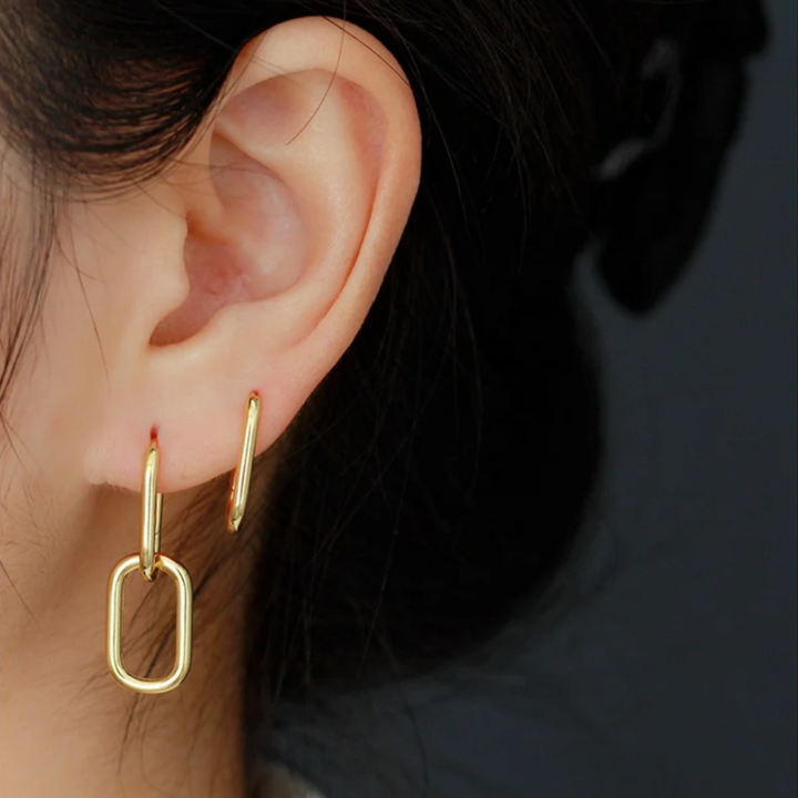 Gold convertible link earrings worn by a person, featuring a small gold hoop and a detachable elongated rectangular link that can be worn together or separately. These versatile earrings are available in Ottawa, Ontario, Canada.