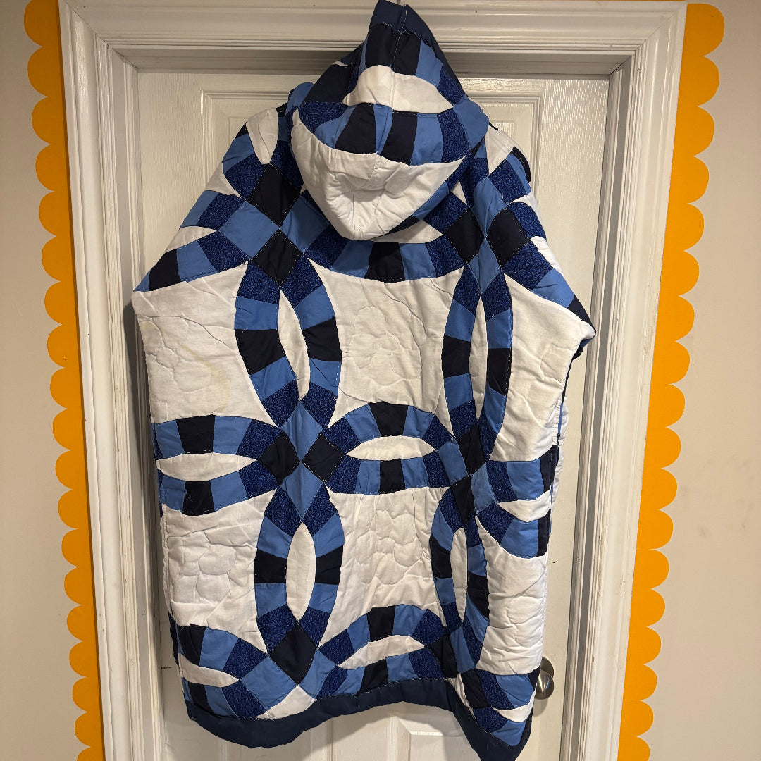A hooded quilt jacket featuring blue and white Double Wedding Ring quilt patterns, hanging on a white paneled door framed by a yellow scalloped border.

If you’d like a more romantic, minimalist, or bold tone, I can shape the description however you like.