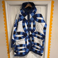A hooded quilt jacket featuring blue and white Double Wedding Ring quilt patterns, hanging on a white paneled door framed by a yellow scalloped border.

If you’d like a more romantic, minimalist, or bold tone, I can shape the description however you like.