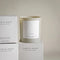 A beige glass jar candle with a white label. The label reads 