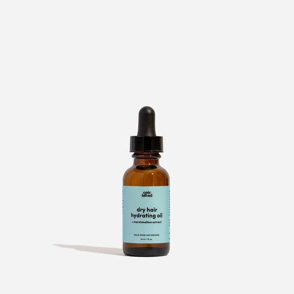 A small, amber glass dropper bottle of Epic Blend dry hair hydrating oil, featuring a light blue label with product details.