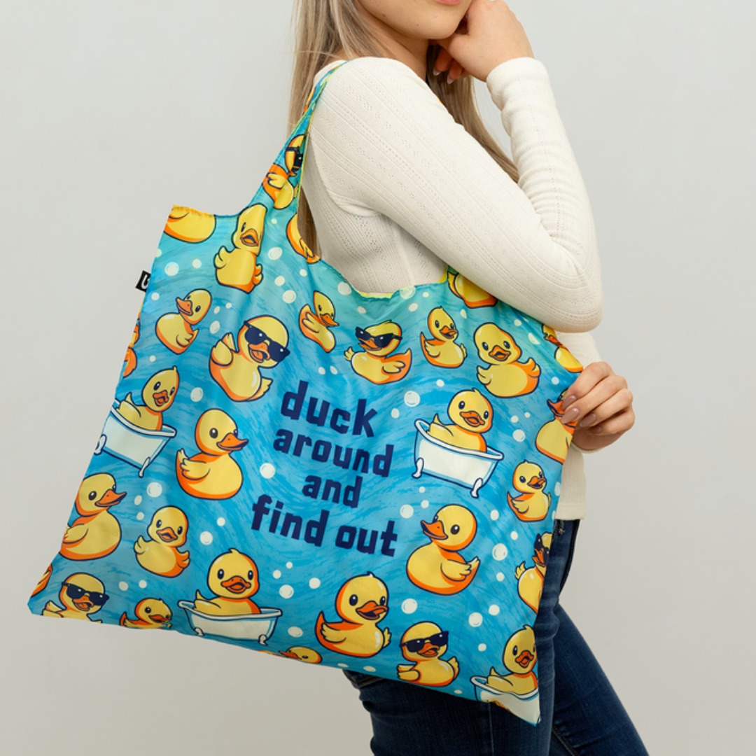 Woman holding a blue tote bag with yellow rubber duck pattern