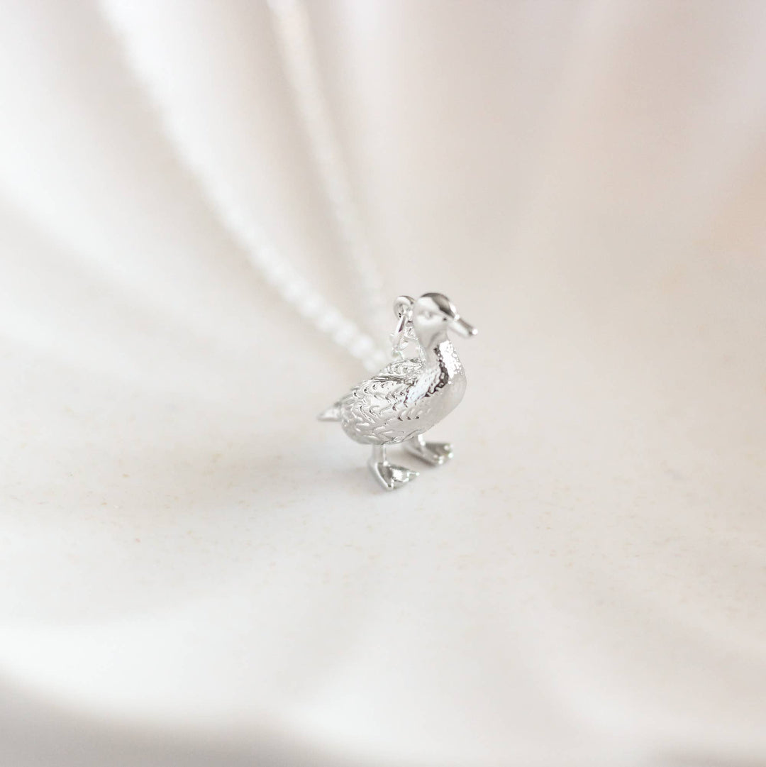 Silver duck-shaped pendant on a light background