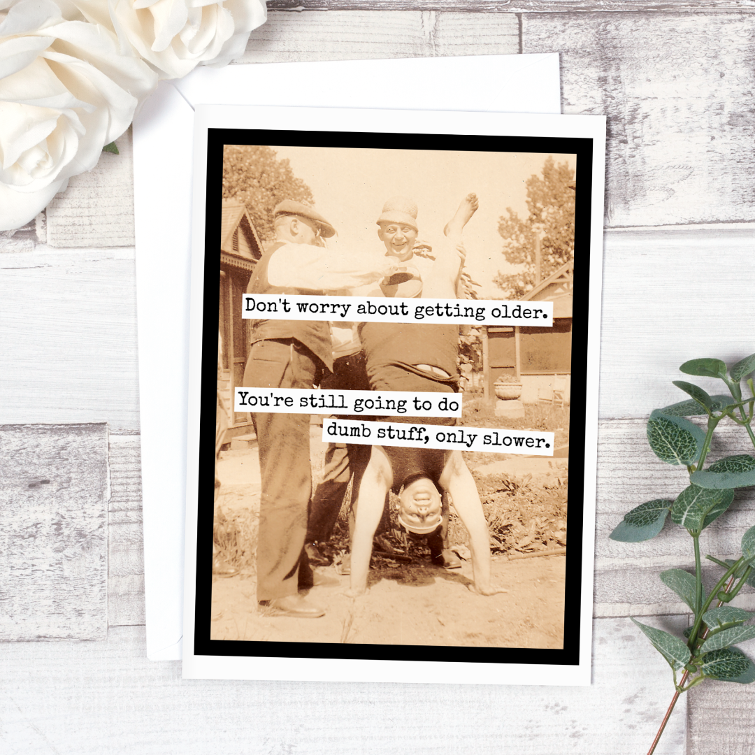 A birthday card with a vintage sepia-toned photo of three men, one doing a handstand. Text on the card reads: "Don't worry about getting older. You're still going to do dumb stuff, only slower."
