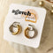 Two-tone chunky hoop huggie earrings (gold and silver) by agaveh girl, displayed on a branded card with the text 'agaveh girl,' against a textured background. The earrings are 4mm thick, made of stainless steel, and are sold in Ottawa, Ontario, Canada