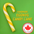 Handmade eggnog candy cane with yellow and white stripes on a green background, featuring Volio's Confections logo.