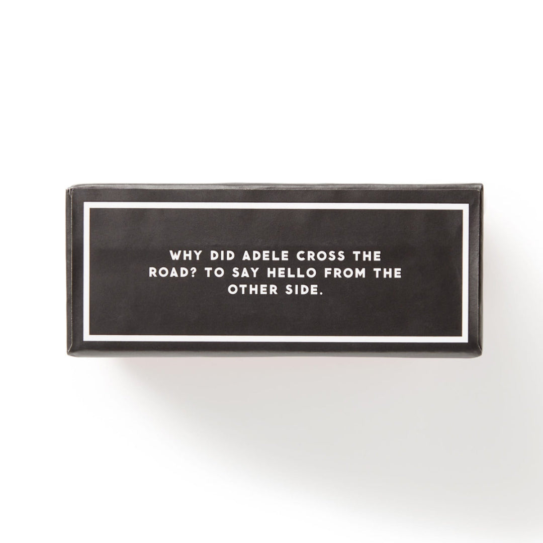 A rectangular black box with white text reading 'WHY DID ADELE CROSS THE ROAD? TO SAY HELLO FROM THE OTHER SIDE.' on a clean white background.