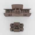 Two brown hair clamps on a white background