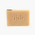 Bar of soap with 'aide' branding on a light gray background