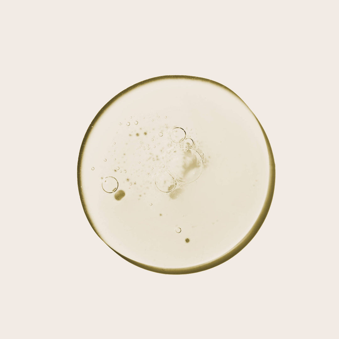 Close-up of a round, beige-colored object with bubbles on a light pink background