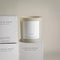 A beige glass jar candle with a white label. The label reads 
