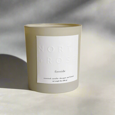 A beige glass jar candle with a white label. The label reads 