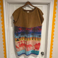 Brown sleeveless top with colorful flamingo design on a hanger against a white door.