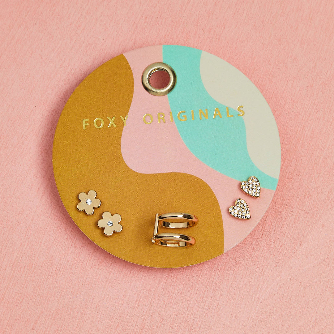 Foxy Originals jewelry display with earrings on a pink background