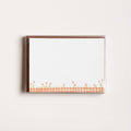 Framed artwork with a checkered pattern and floral design on a white wall.