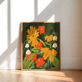 Framed artwork of colorful flowers on a wall with sunlight casting shadows.