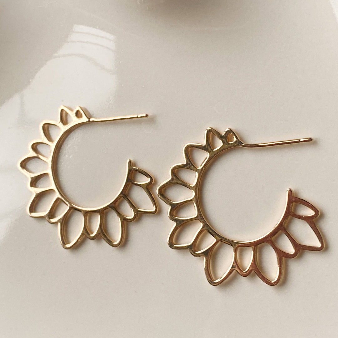 Gold hoop earrings on a white mannequin bust