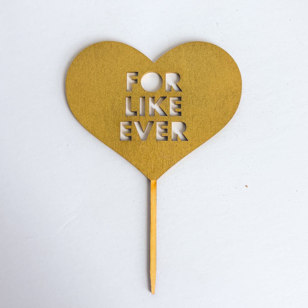 Heart-shaped gold topper with 'For Like Ever' text on a white background